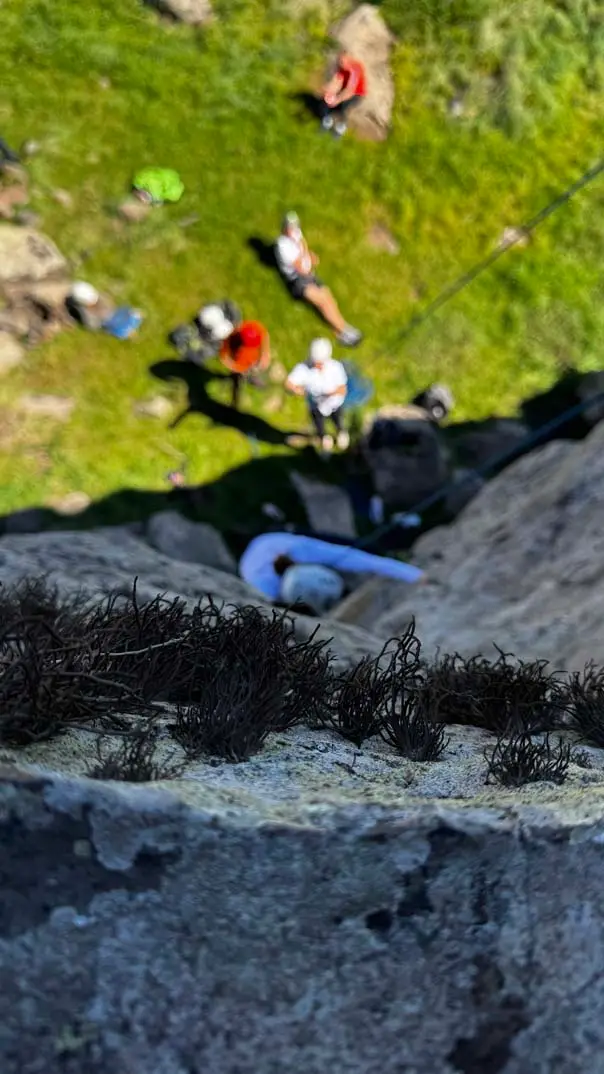Climber reaching the top of a sea cliff in Madeira